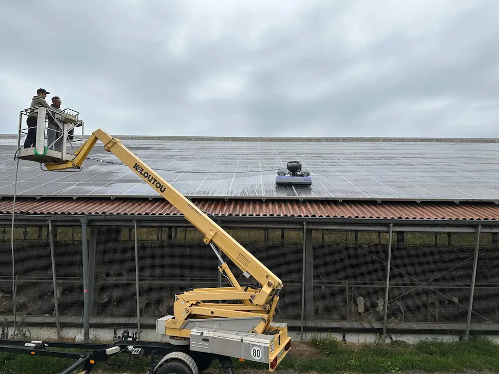 Robosun_Gallery_11 - Robosun Two technicians in a yellow boom lift basket inspecting rooftop solar panels on a flat roof.